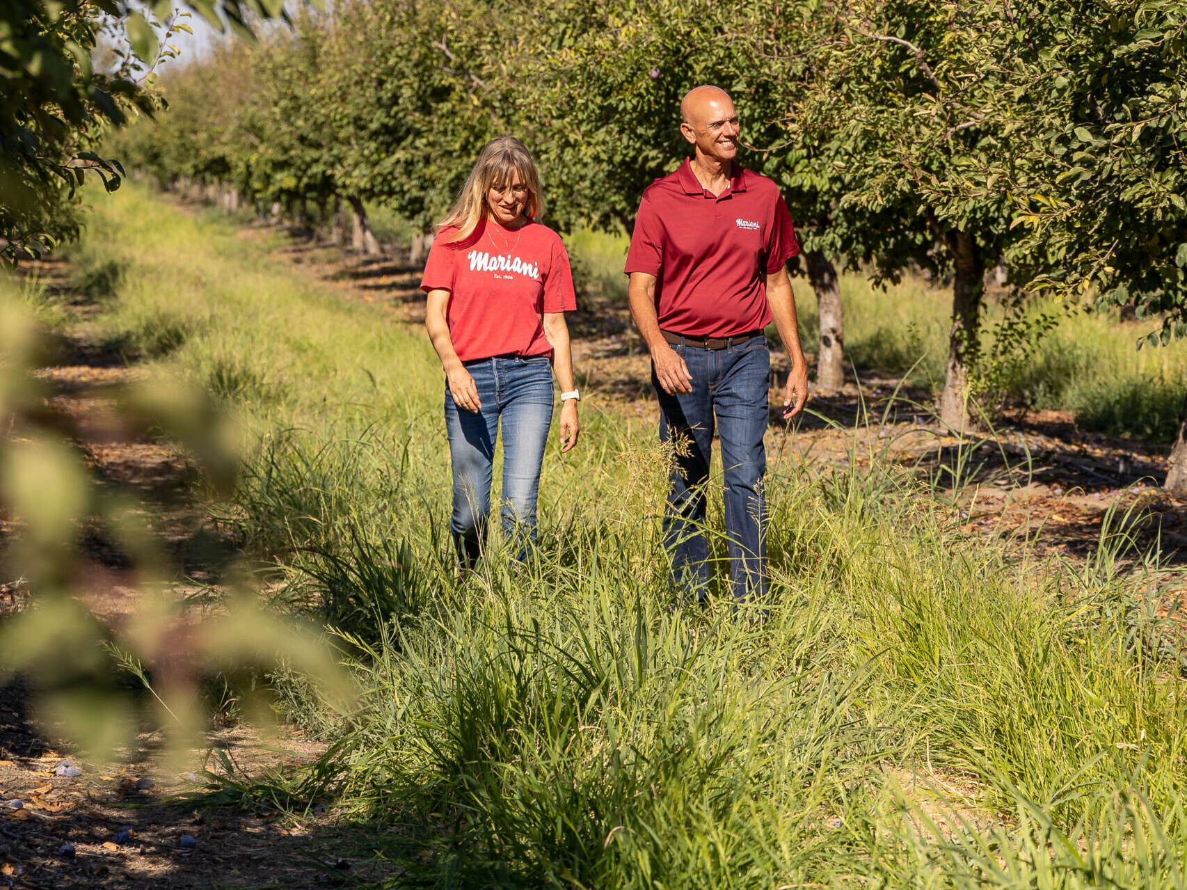 George Souza Jr, President of Mariani Family with Natalie Mariani Kling, Director of Strategic Marketing walking through their Yuba City Prune Orchard August 2022 Photography by Hilary Rance for California Prunes